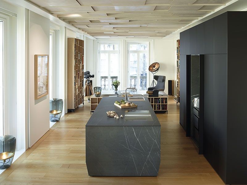 Bucatarie deschisa neagra inconjurata de tonuri neutre