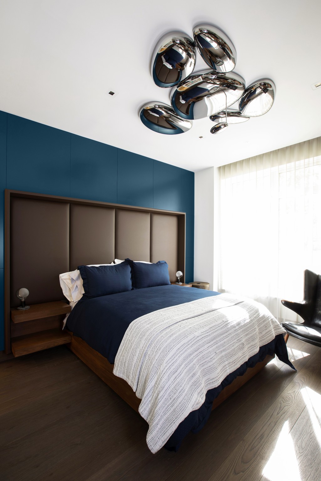 Dormitor de culoare galbena cu corp de iluminat argintiu